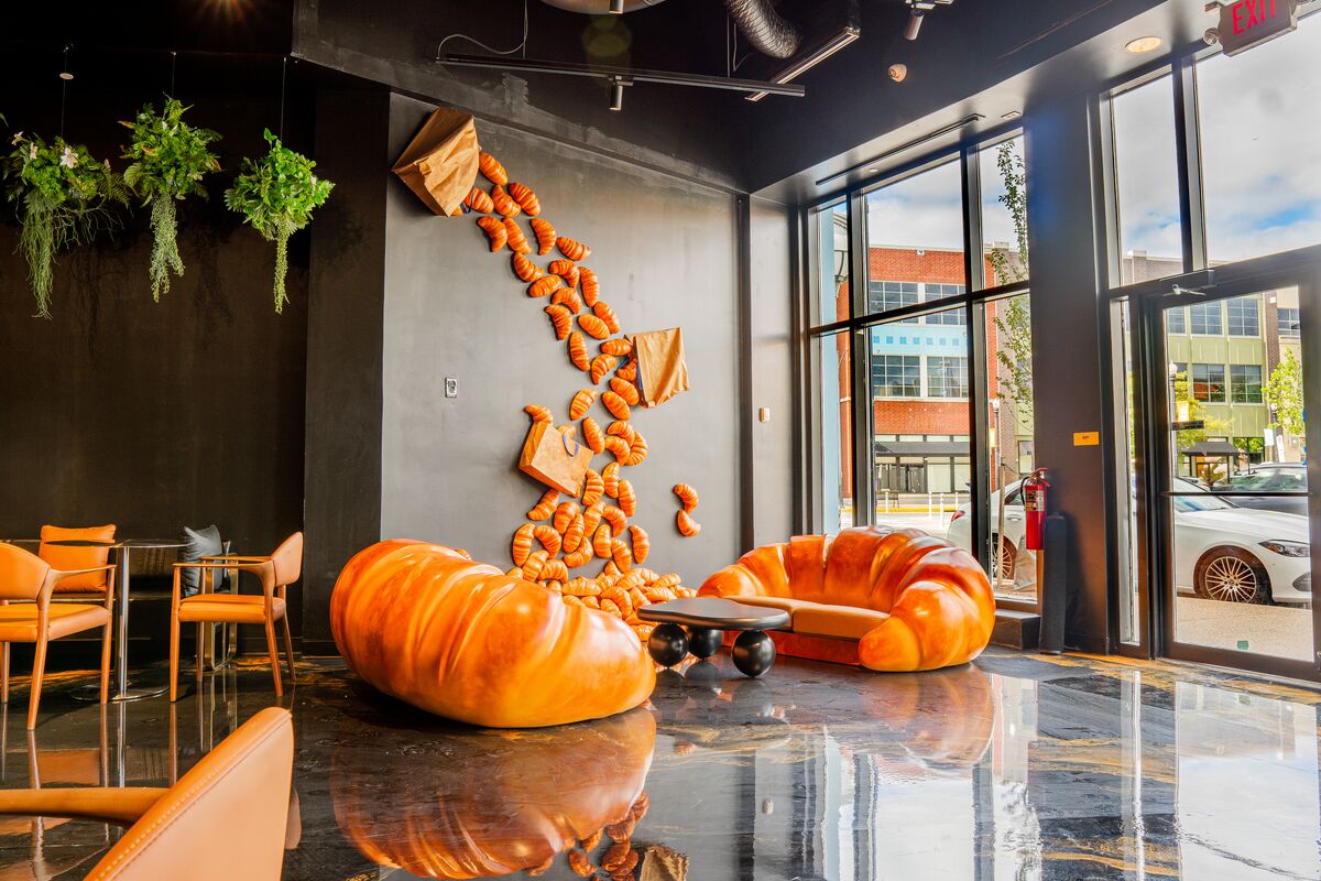 Croissant-shaped sofas beneath croissant wall art