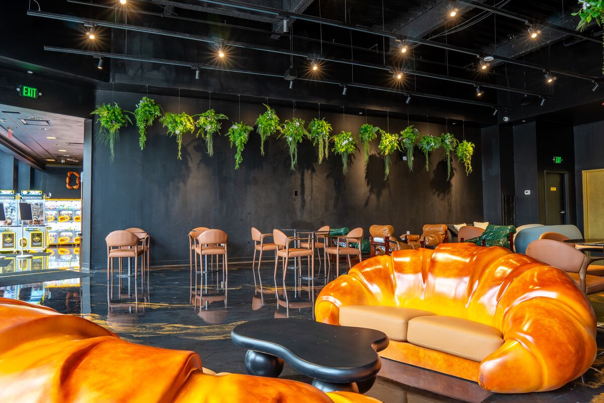 Croissant sofa below a wall of hanging greenery