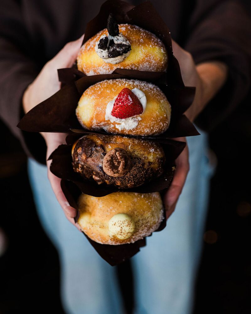 Four filled buns held in a stack