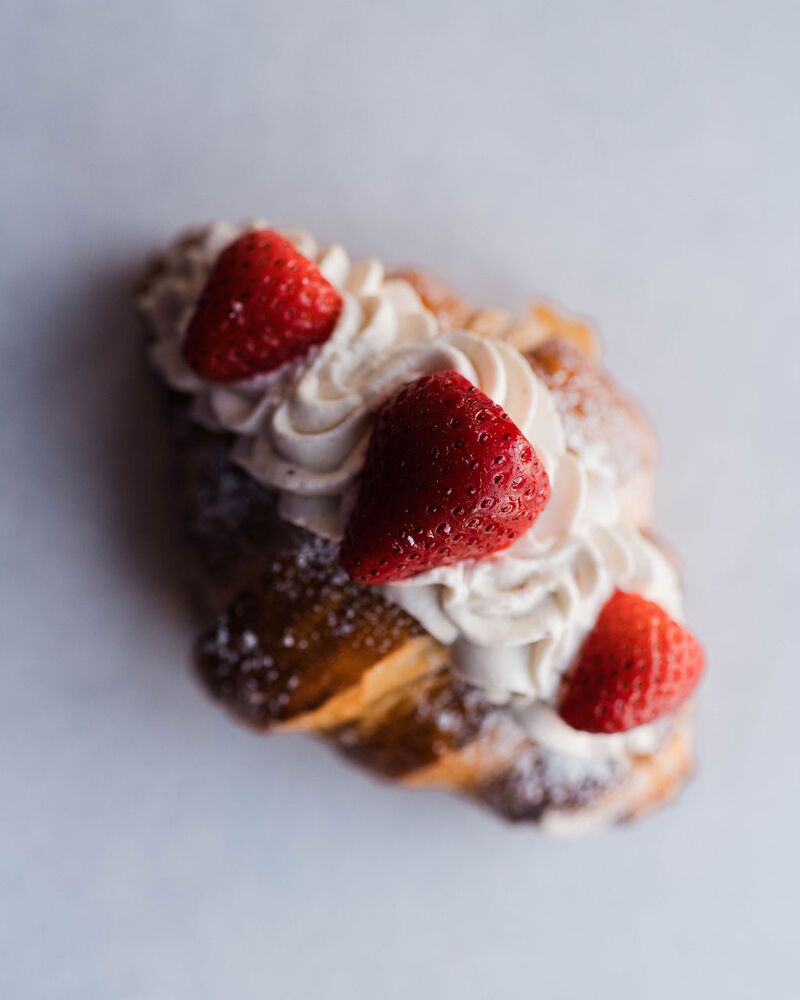 Croissant topped with whipped cream and strawberries