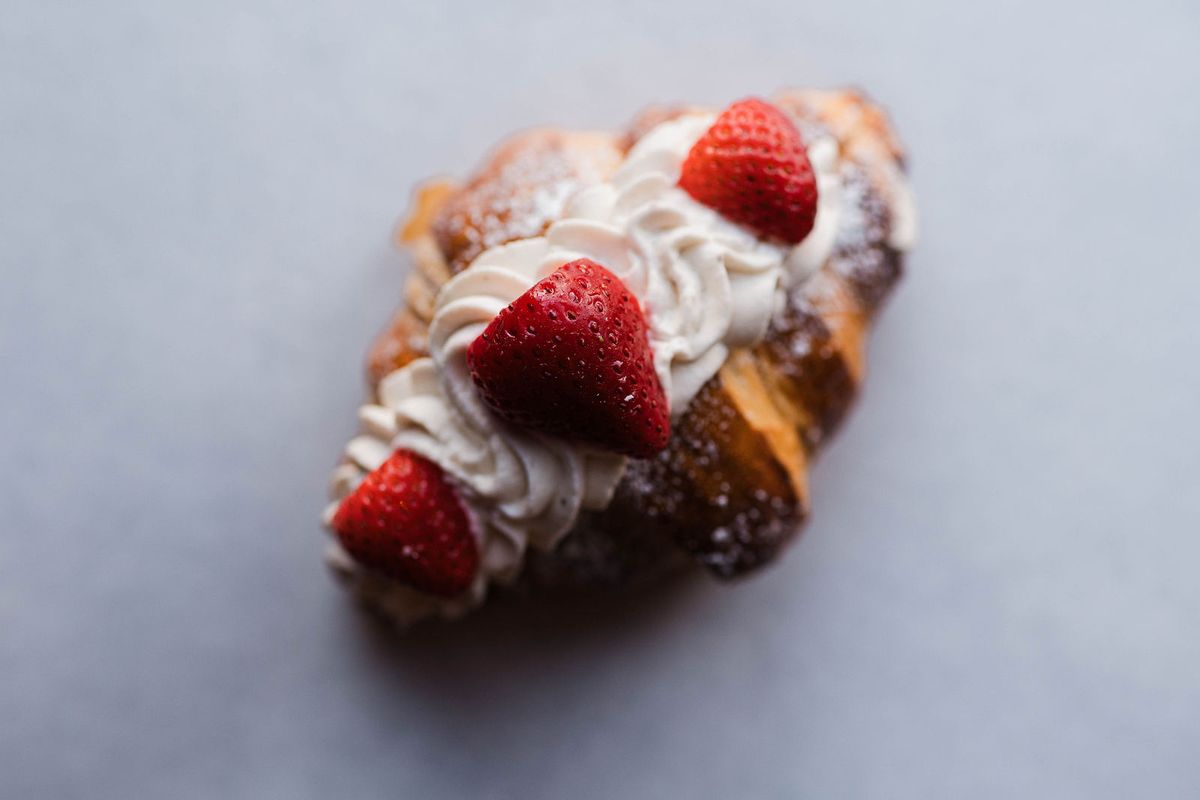 Croissant topped with whipped cream and strawberries